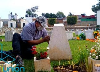 Desde temprana hora Don José se encuentra en el panteón retocando letras en tumbas para llevar comida a casa