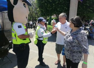 Policías de Tránsito del estado dan la bienvenida a turistas y paseantes con una botella de agua para beber
